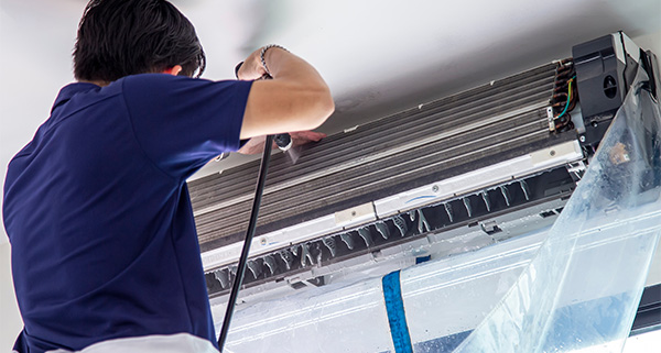 a man installing a wall mounted air conditioning unit