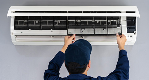 a man installing the filters into an air conditioning unit