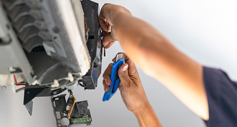 a person repairing an air conditioning temperature system