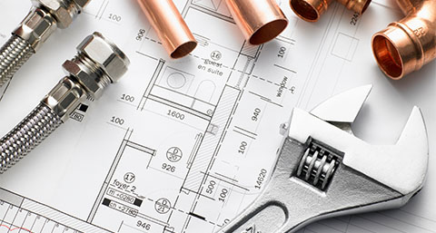 a wrench and air source heat pump components on top of floor plans