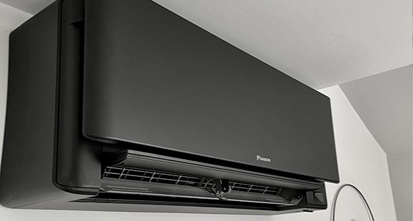 a black air conditioning unit installed onto a wall