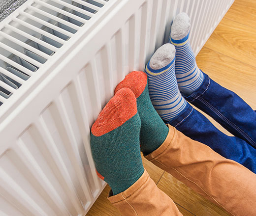 two people putting their feet against a warm radiator 